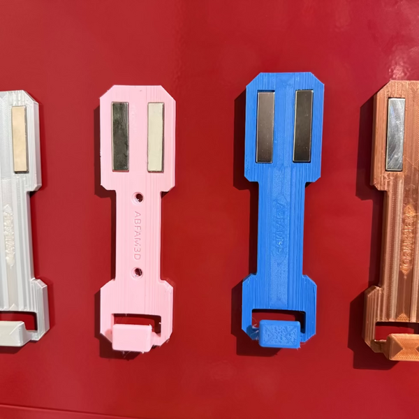 Durable 3D printed spray can holder attached to metal cabinet for shop storage